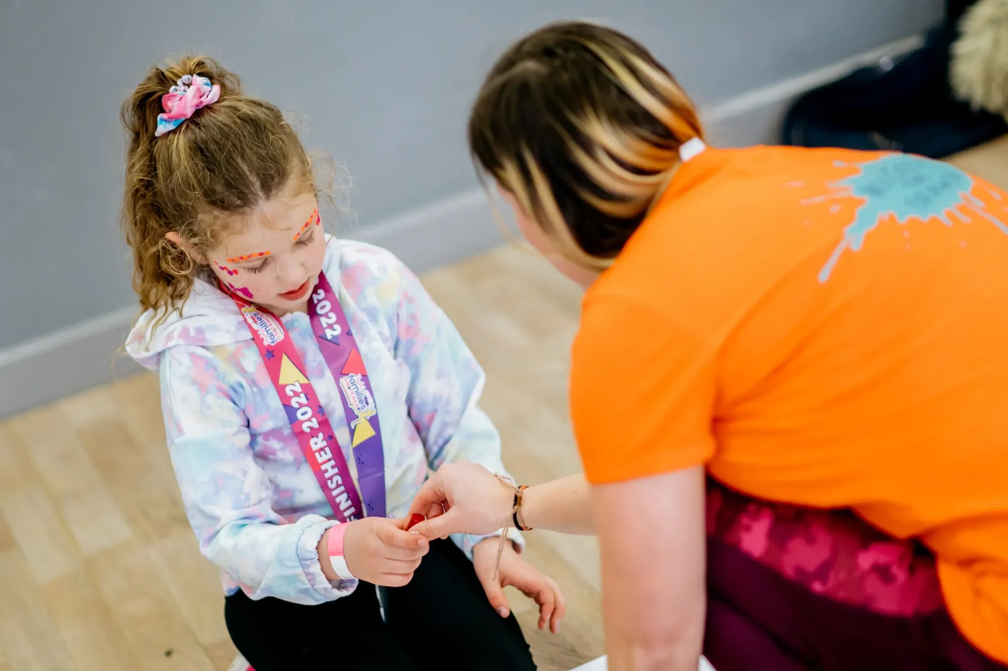 Hazel helping a young girl with her drawing at a workshop table