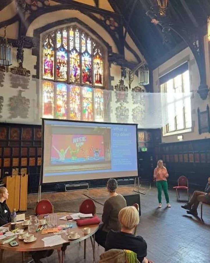 An audience in a church hall watching Hazel’s slides