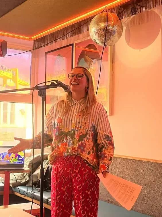 Hazel speaking into a microphone at an evening event